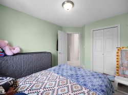 Bedroom featuring light green walls, white trim, and a white ceiling with a flush-mount light fixture - 