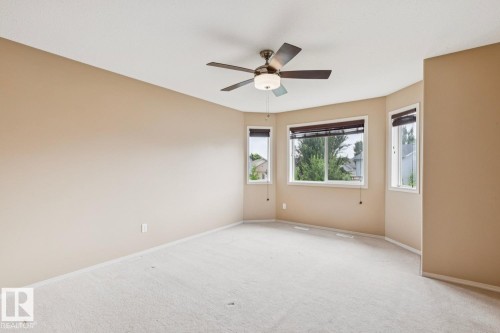 Spacious room featuring light neutral wall paint and light-colored carpeting - 16765 119 Street Nw, Edmonton, AB - Indoor Photo Showing Other Room
