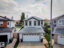Two-story residence featuring white siding with contrasting trim, a front-facing attached garage, and a peaked roofline - 16765 119 Street Nw, Edmonton, AB  - Outdoor 