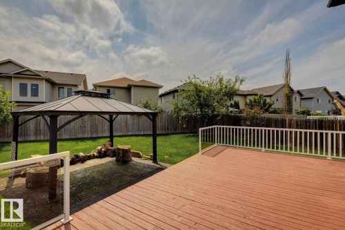 Expansive backyard featuring a spacious wood deck with white railings, a covered gazebo, and a stamped concrete patio area - 16765 119 Street Nw, Edmonton, AB - Outdoor With Deck Patio Veranda