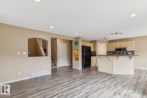 Open-concept living area featuring wood-finish flooring, recessed lighting, and a neutral wall color - 16765 119 Street Nw, Edmonton, AB - Indoor Photo Showing Kitchen