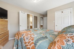 Carpeted bedroom featuring neutral wall tones, white trim, and white paneled doors - 
