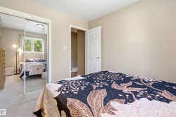 Bedroom featuring neutral wall paint, carpeted flooring, and a white paneled door - 