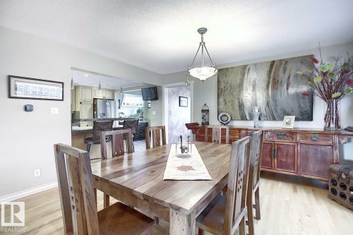 Dining room featuring hardwood floors and a wooden dining table - 11126 52 Street Nw, Edmonton, AB - Indoor Photo Showing Dining Room