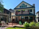 Front exterior featuring a second-story balcony with wood railing, a ground-level deck with steps, a pergola, a brick patio. - 11126 52 Street Nw, Edmonton, AB  - Outdoor With Deck Patio Veranda 
