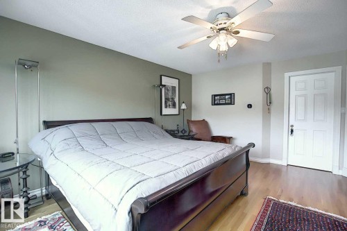 This room features light hardwood flooring and a white paneled door - 11126 52 Street Nw, Edmonton, AB - Indoor Photo Showing Bedroom