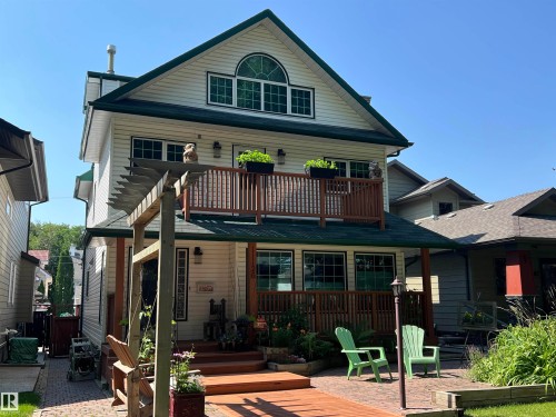Cream-colored siding exterior with dark green trim and roofing - 11126 52 Street Nw, Edmonton, AB - Outdoor With Deck Patio Veranda