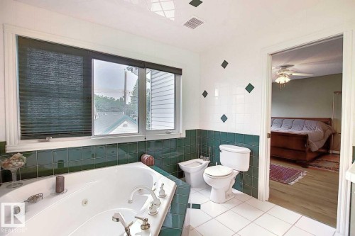 The bathroom features a corner soaking tub, a toilet, and a bidet - 11126 52 Street Nw, Edmonton, AB - Indoor Photo Showing Bathroom