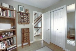 This area features light wood flooring, white trim, and a white closet with bi-fold doors - 