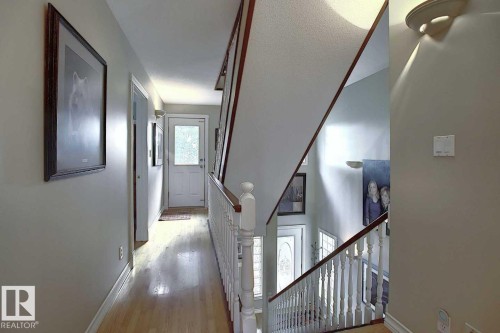 Hallway featuring hardwood floors, light-colored walls, and a white paneled door with a window - 11126 52 Street Nw, Edmonton, AB - Indoor Photo Showing Other Room
