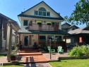 Three-story residence featuring light-colored siding and a dark green roof - 11126 52 Street Nw, Edmonton, AB  - Outdoor With Deck Patio Veranda With Facade 