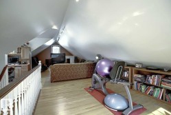 This versatile space features sloped ceilings, hardwood flooring, and recessed lighting - 