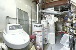 Utility room featuring water heaters and a water softener - 