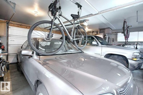 Spacious garage with overhead lighting and a white paneled garage door - 11126 52 Street Nw, Edmonton, AB - Indoor Photo Showing Garage