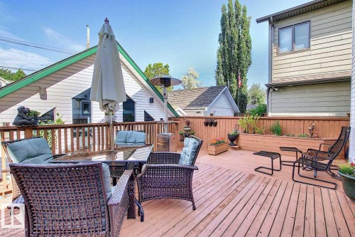Expansive outdoor deck featuring wood flooring, a wooden railing, and an integrated planter box - 11126 52 Street Nw, Edmonton, AB - Outdoor With Deck Patio Veranda With Exterior