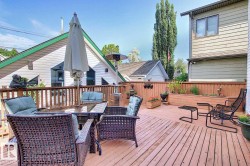 Expansive outdoor deck featuring wood flooring, a wooden railing, and an integrated planter box - 