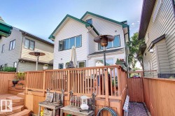The property features a multi-level wooden deck with natural wood railings - 