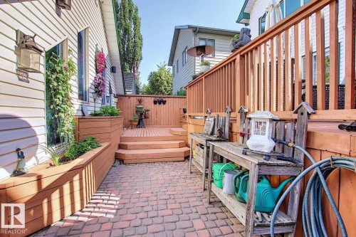 The property features a brick paved patio, a wooden deck with steps, and an integrated wooden planter box - 11126 52 Street Nw, Edmonton, AB - Outdoor With Deck Patio Veranda With Exterior