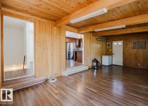 Spacious room featuring wood-panel walls and ceiling with exposed beams - 11115 39A Avenue Nw, Edmonton, AB - Indoor Photo Showing Other Room