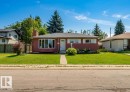 Single-story residence featuring a red siding exterior, white trim, and a prominent front bay window - 11115 39A Avenue Nw, Edmonton, AB  - Outdoor With Facade 