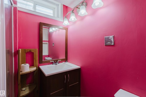 Bathroom featuring a vanity with a white sink, a wood-framed mirror, and a five-bulb light fixture - 11115 39A Avenue Nw, Edmonton, AB - Indoor Photo Showing Bathroom