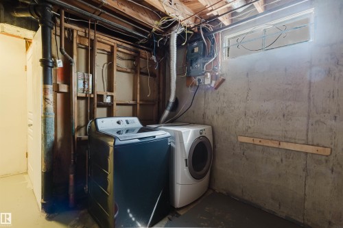 Laundry area featuring exposed ceiling joists, concrete walls, a window, and wood wall framing - 11115 39A Avenue Nw, Edmonton, AB - Indoor Photo Showing Laundry Room