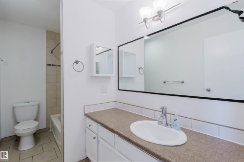 Bathroom vanity featuring a single basin sink, chrome faucet, and expansive wall-mounted mirror - 134 Callingwood Place Nw, Edmonton, AB - Indoor Photo Showing Bathroom