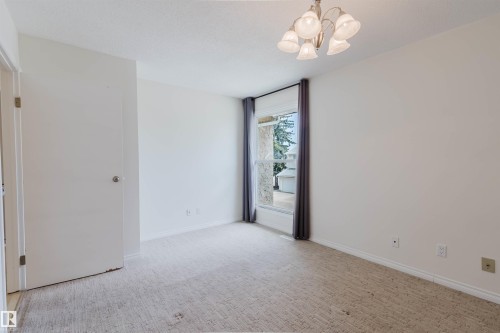 Neutral-toned room featuring a window with natural light, wall-to-wall carpeting, and a multi-bulb chandelier - 134 Callingwood Place Nw, Edmonton, AB - Indoor Photo Showing Other Room