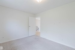 Room with light-colored carpeting, white baseboards, and a white ceiling - 