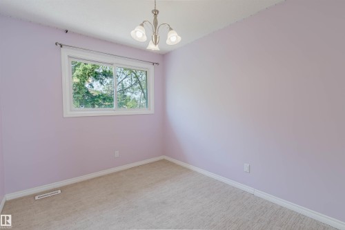 Room with light purple walls, a large window, and beige carpet flooring - 134 Callingwood Place Nw, Edmonton, AB - Indoor Photo Showing Other Room
