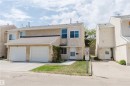Two-story stucco exterior featuring a two-car attached garage, asphalt shingle roofing, and a concrete driveway - 134 Callingwood Place Nw, Edmonton, AB  - Outdoor With Facade 