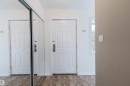 Entryway featuring wood-finish flooring, a white panel door, and a mirrored sliding closet door - 134 Callingwood Place Nw, Edmonton, AB  - Indoor Photo Showing Other Room 