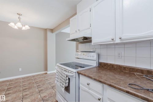 Kitchen with white cabinetry, a flat-top electric range, and a white tile backsplash - 134 Callingwood Place Nw, Edmonton, AB - Indoor Photo Showing Kitchen