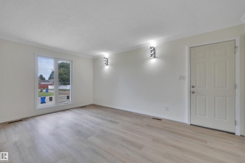 Room featuring light wood-finish flooring, white walls, and a large picture window - 3607 53 Street, Wetaskiwin, AB - Indoor