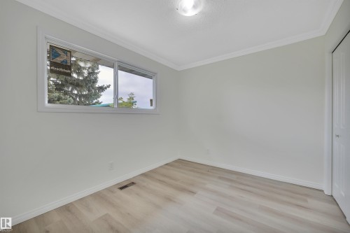 Spacious room featuring wood-finish flooring, white baseboards, and a window with white trim - 3607 53 Street, Wetaskiwin, AB - Indoor Photo Showing Other Room