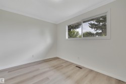 Room featuring light wood-finish flooring, white baseboards, and crown molding - 