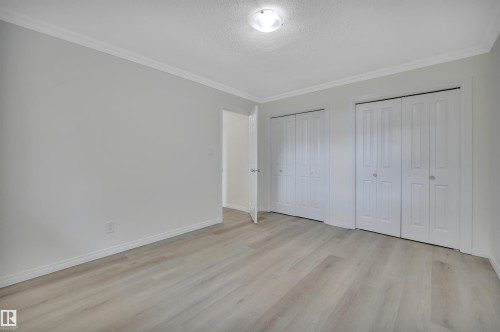 Spacious room featuring light wood-finish flooring, light gray walls, and white crown molding - 3607 53 Street, Wetaskiwin, AB - Indoor Photo Showing Other Room