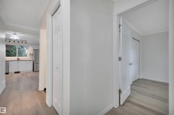 Hallway with wood-finish flooring and light gray wall paint - 