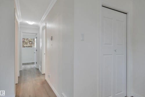 Hallway featuring wood-finish flooring, white walls, and crown molding - 3607 53 Street, Wetaskiwin, AB - Indoor Photo Showing Other Room