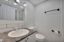 Bathroom vanity with an oval undermount sink, dual-handle chrome faucet, and a stone-look countertop - 