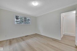 Light-filled room featuring wood-finish flooring and a white trim package - 