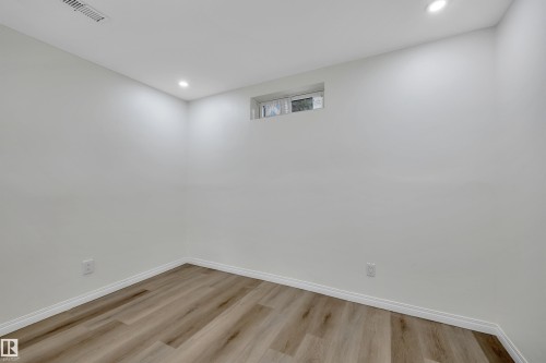 Neutral white wall finishes with recessed lighting and wood-finish flooring - 3607 53 Street, Wetaskiwin, AB - Indoor Photo Showing Other Room