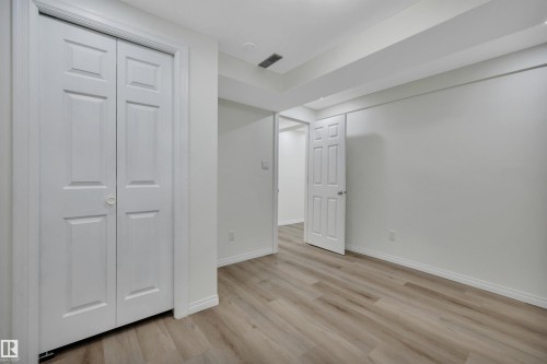 Room featuring wood-finish flooring, white baseboards, and bright white walls - 3607 53 Street, Wetaskiwin, AB - Indoor Photo Showing Other Room