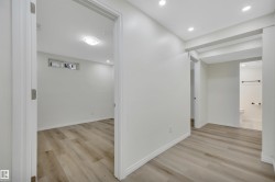 Interior space featuring wood-finish flooring, recessed lighting, and crisp white walls - 