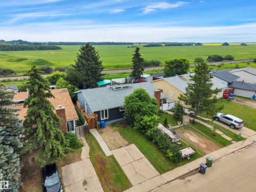 Single-story residence featuring dark siding, a light gray roof, and a paved driveway - 3607 53 Street, Wetaskiwin, AB - Outdoor With View