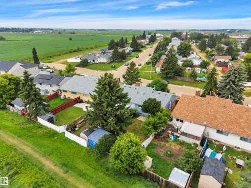 Aerial perspective showcasing residential properties with surrounding green spaces and agricultural fields - 3607 53 Street, Wetaskiwin, AB - Outdoor With View