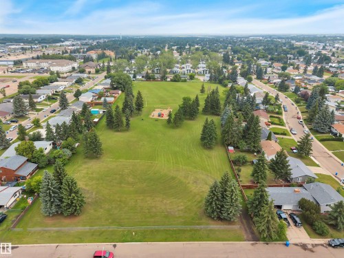 Expansive green space featuring mature evergreen trees and recreational equipment - 3607 53 Street, Wetaskiwin, AB - Outdoor With View