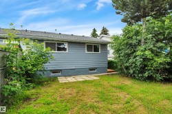 Rear exterior featuring horizontal siding, a shingle roof, and multiple windows - 