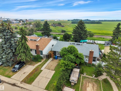 Two residential properties featuring shingled roofs and established landscaping - 3607 53 Street, Wetaskiwin, AB - Outdoor With View