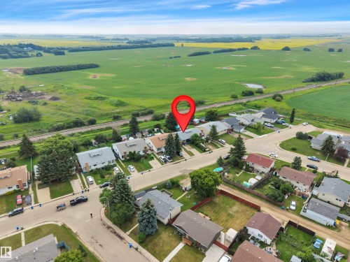 Residential street featuring single-story homes with individual driveways and green lawns - 3607 53 Street, Wetaskiwin, AB - Outdoor With View